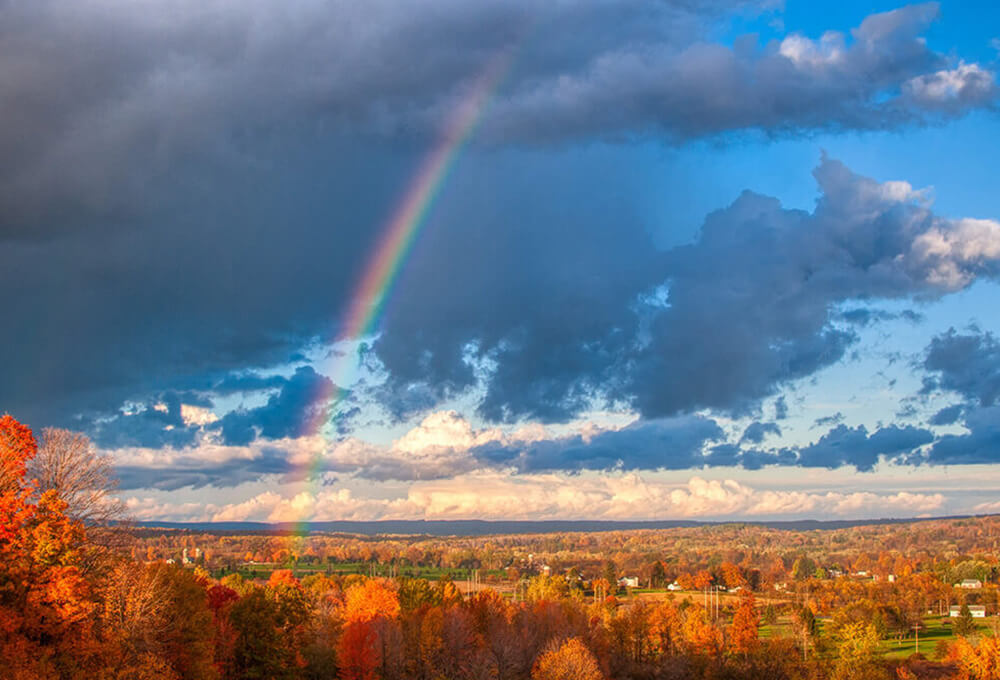 Peaceful rainbow in an autumn landscape representing beauty and God’s creation