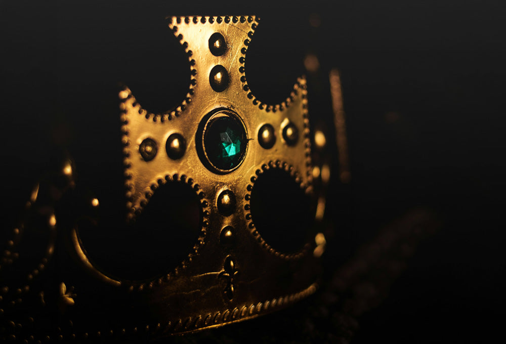 richly jeweled kings crown on a table
