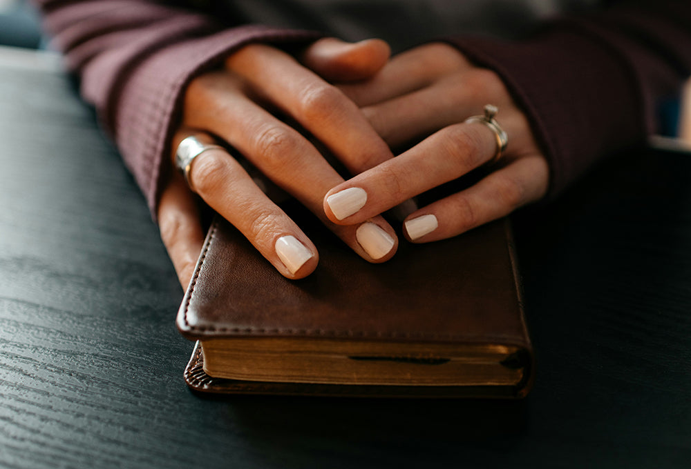 Hands on a bible during prayer