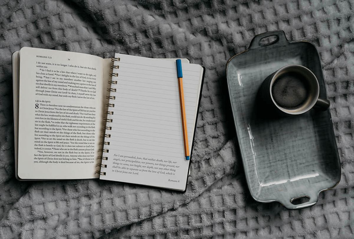 Open personalized bible journal with a cup of coffee and a pencil for bible journaling