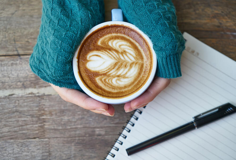 Woman with a cup of coffee and her journal