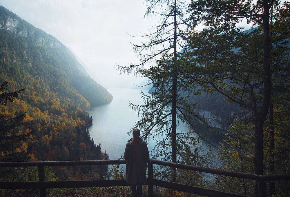 Woman Standing by a peaceful lake in the mountains