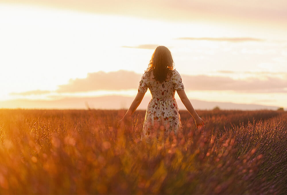 Woman walking beneath an open sky as a symbol of God’s strength and care