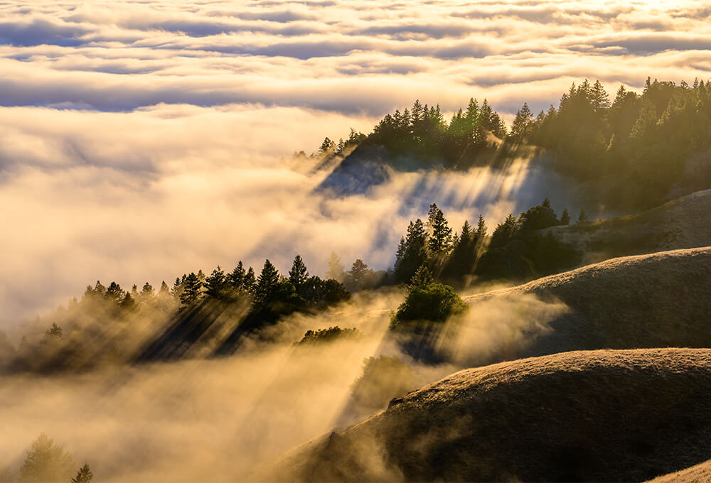 Fog rolling over the mountains at dawn