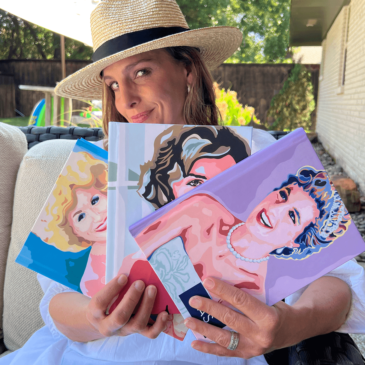 Paper Sunday owner Kara Heckel holding several of Carolyn Joe designed covers