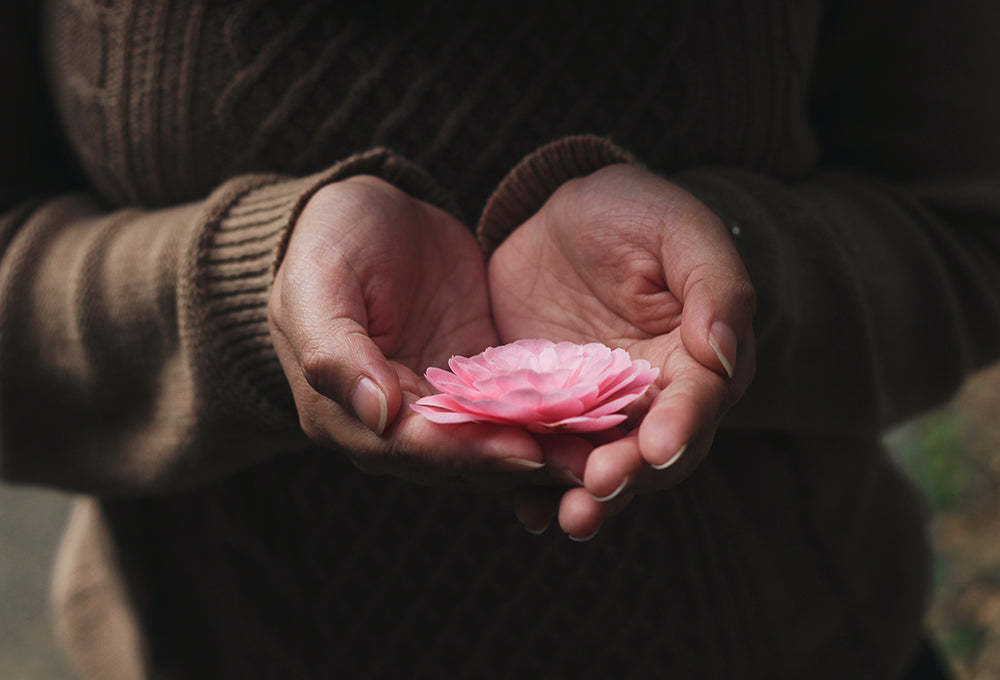 woman holding pink flower showing hope and faith
