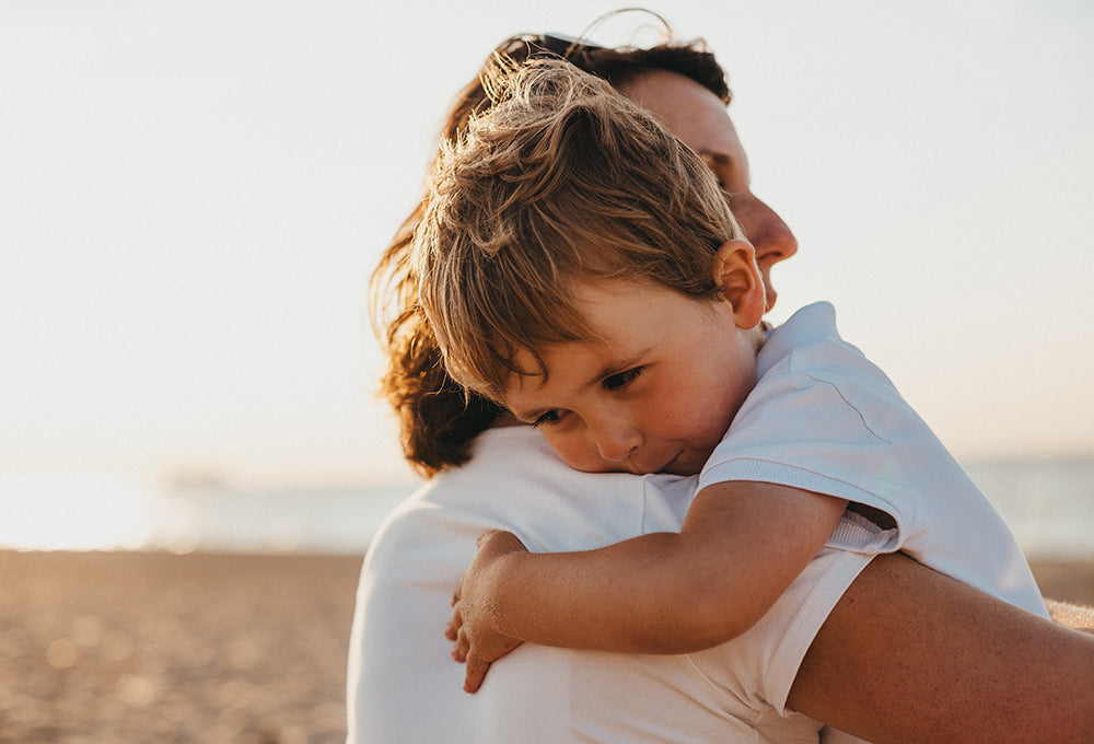 Mother holding baby on beach symbolizing peace and trust