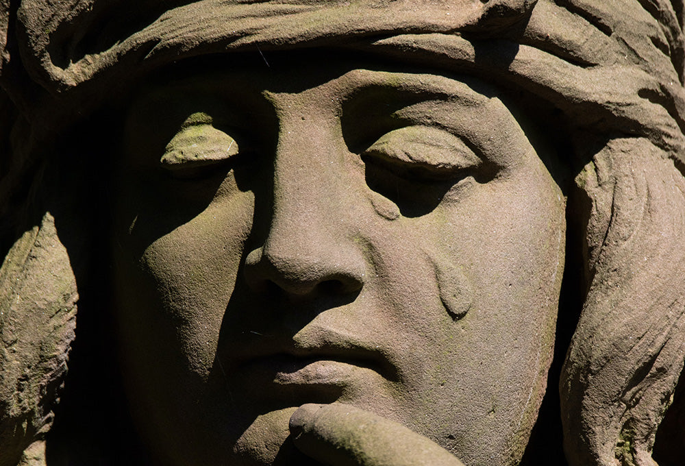 Image of a sculpture of a woman Woman with tears during quiet prayer