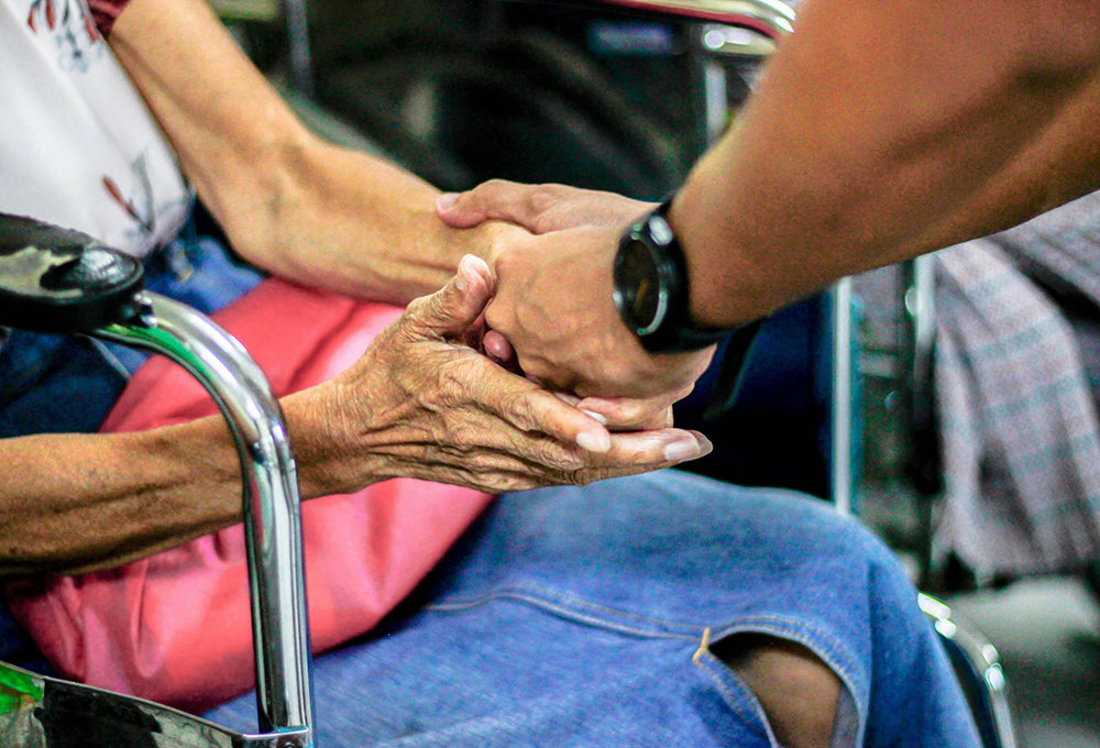 Man practicing greatness through serving by helping an elderly woman.