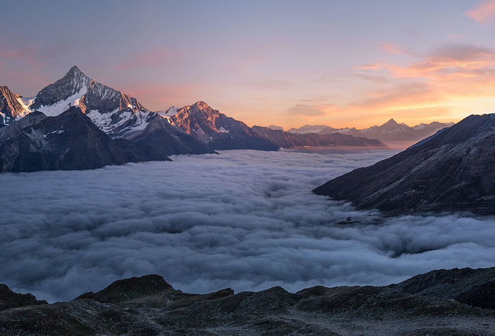 Sunlight streaming through mountain range and clouds symbolizing grace and renewal