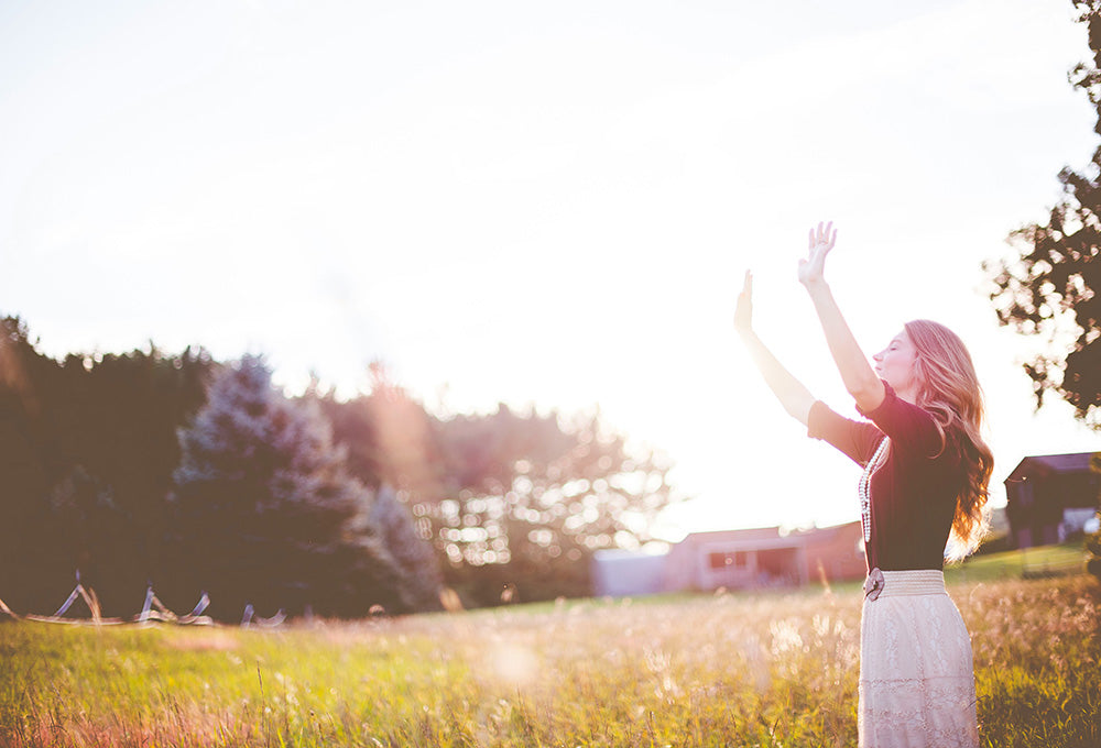 Woman standing with hands raised in worship