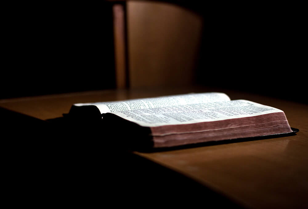 Open bible on wooden desk