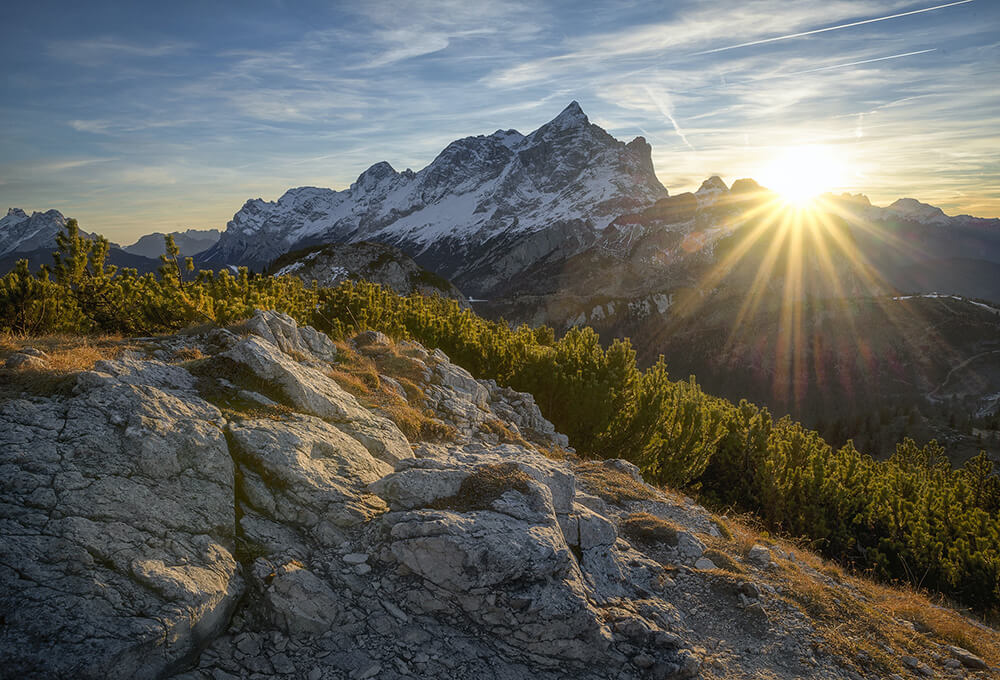 mountains landscape with a bright sun and calm sky
