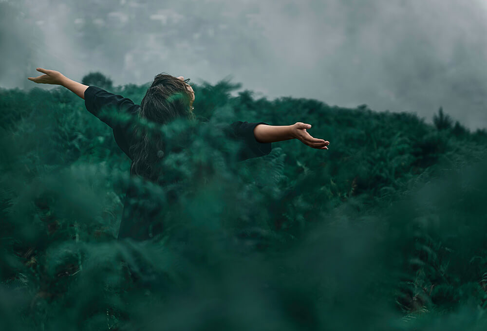 Person with arms open to the heavens symbolizing joy and hope in God