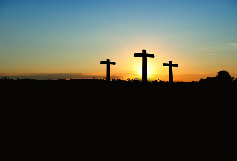 A sunrise behind three crosses
