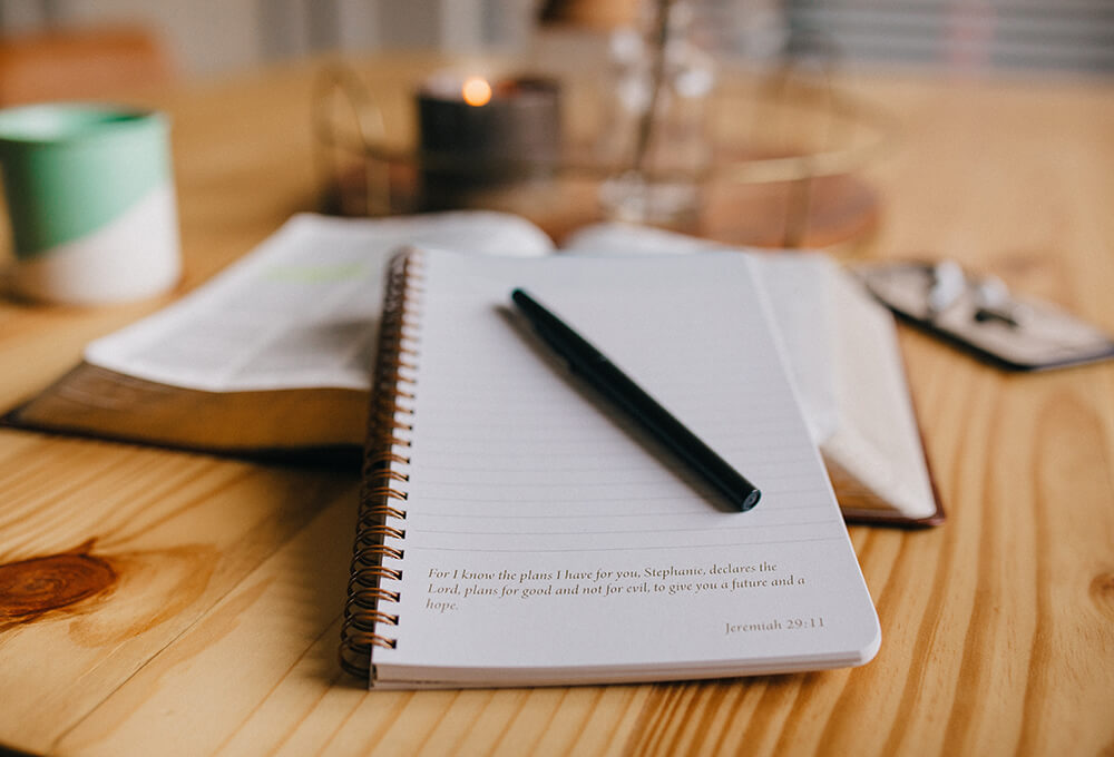 A personalized scripture journal ready for journaling with a bible and coffee on the table
