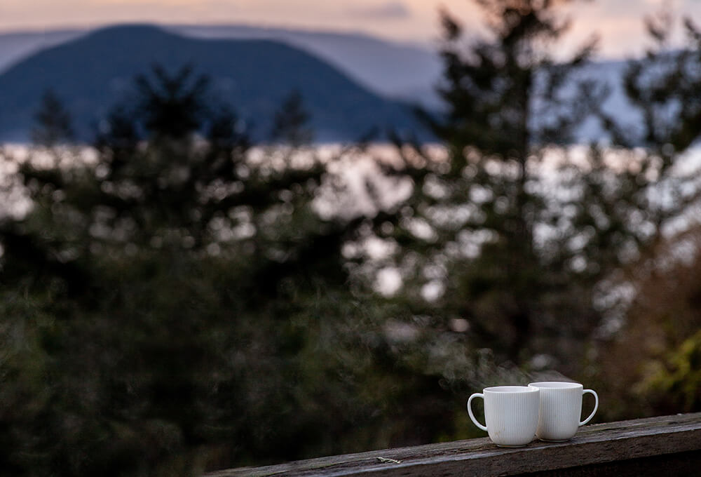 Lakeside morning view of the mountains with coffee