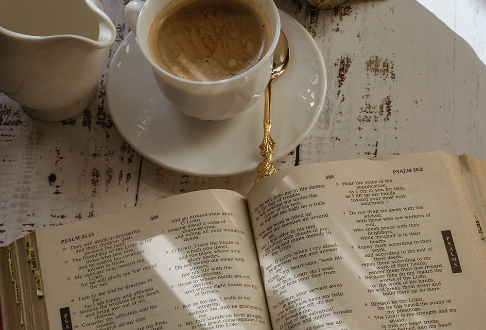 Open Bible in the morning next to a cup of coffee