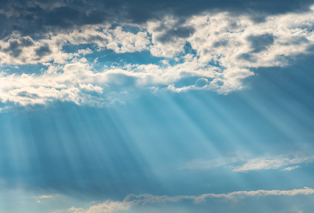 Sun shining through beautiful clouds representing Gods power and reach