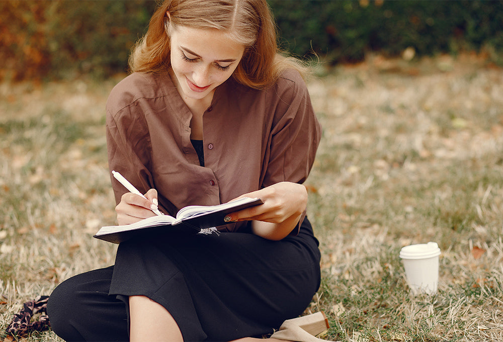 Woman Journaling in a Field of Flowers