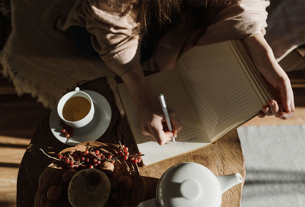 Hands writing a gratitude list in a journal