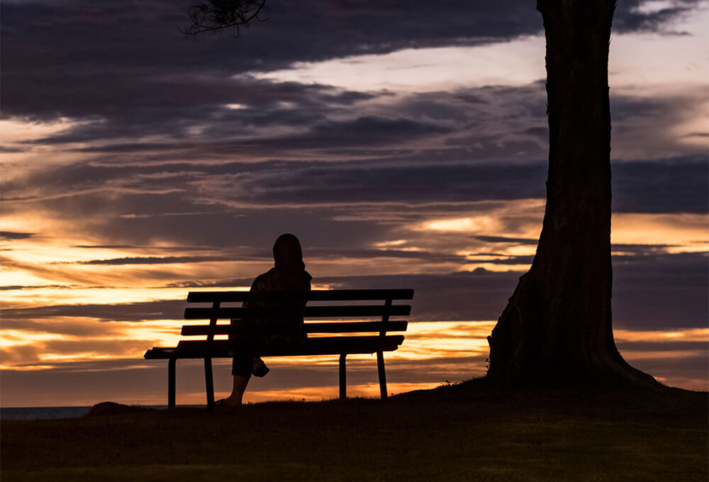 Woman Sitting alone at sunset