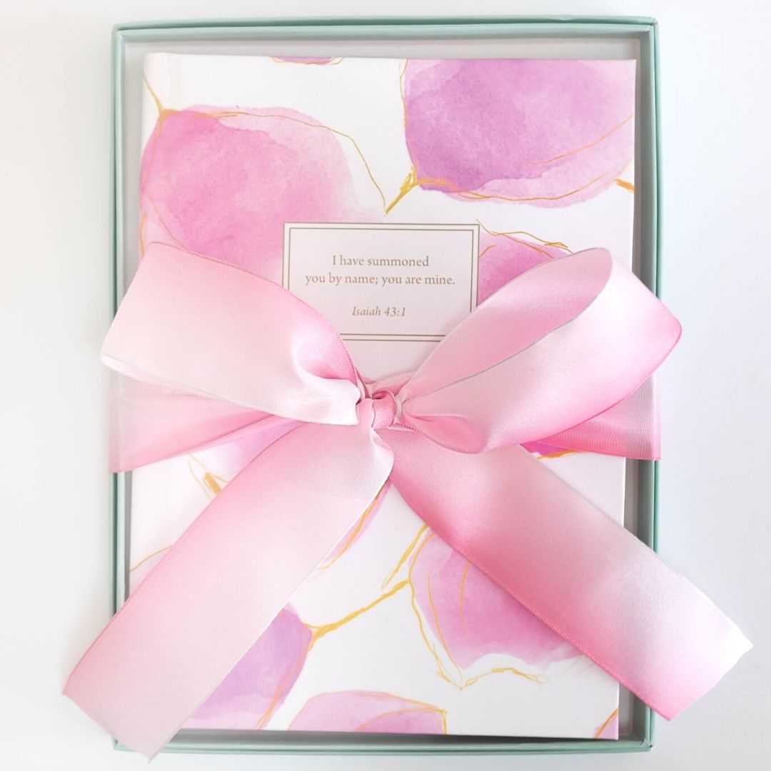 Pink christian journal with beautiful bow and gift box representing a perfect christian gift