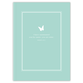 A planner with a light teal cover featuring a white frame and a butterfly design, with personalized scripture verse printed on it.