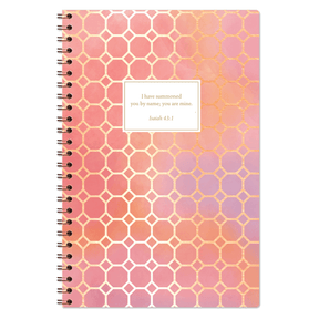 The image displays the cover of a planner with a honeycomb pattern in shades of pink and orange, and a rectangular text box with a quote from Isaiah 43:1 that reads, 'I have promised you by my name you are mine.'.