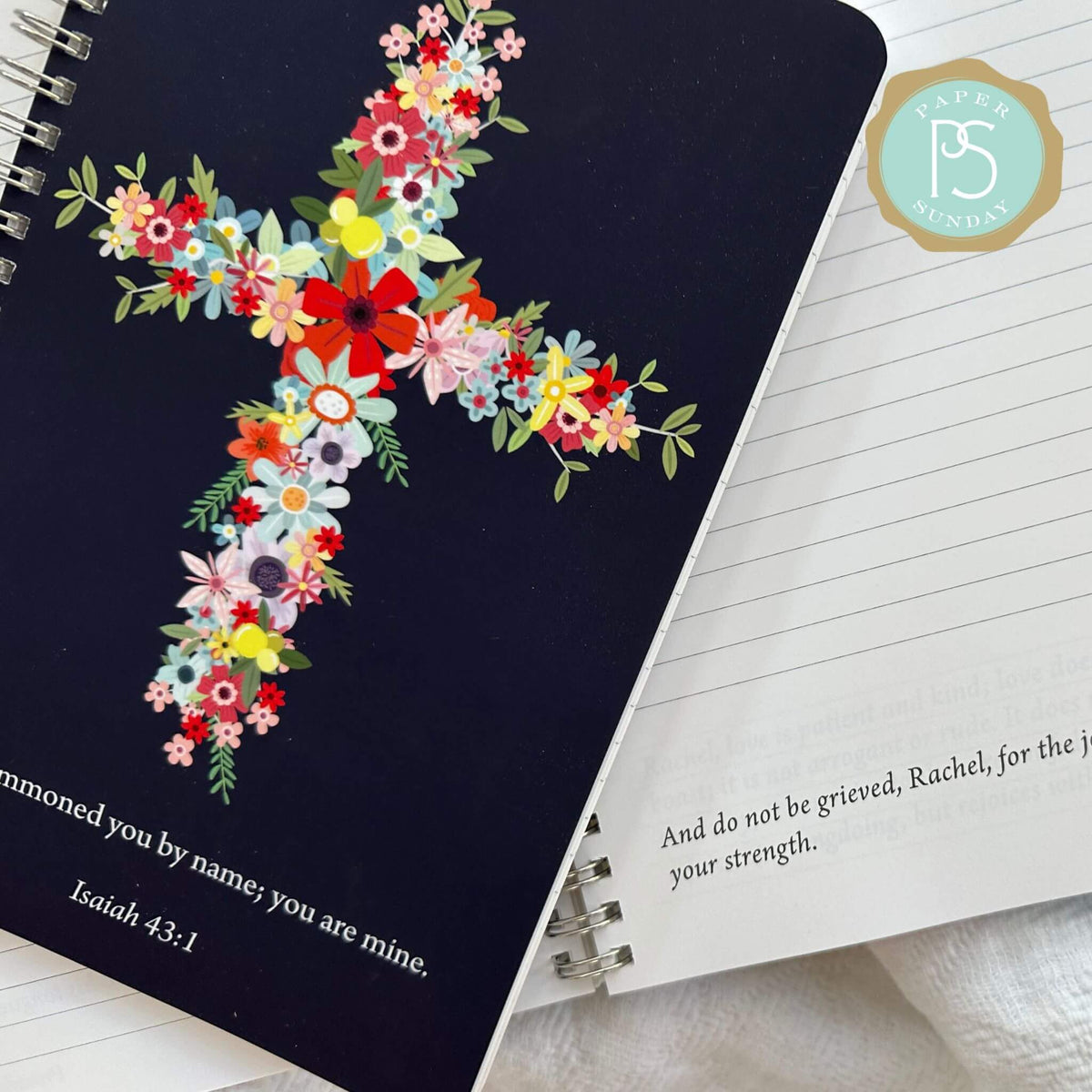Wire coil personalized scripture journal laid on top of an open page with personalized scripture.