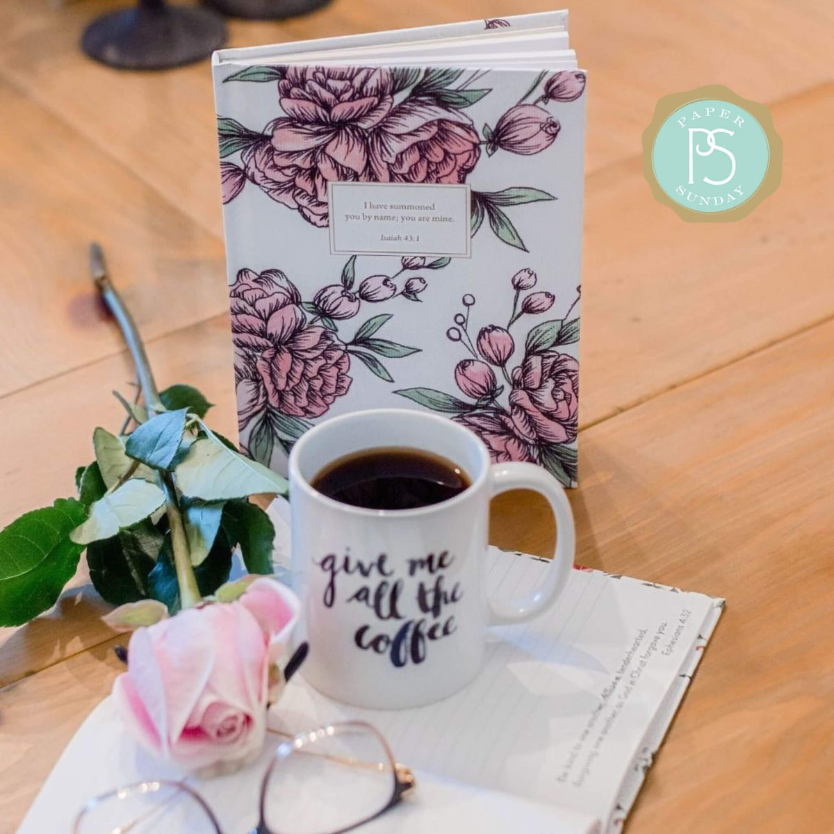 personalized planner with floral design placed on table next to flower