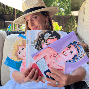 Paper Sunday owner Kara Heckel holding several of Carolyn Joe designed covers